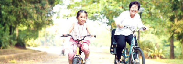 Mother and daughter enjoying bike ride in the park together