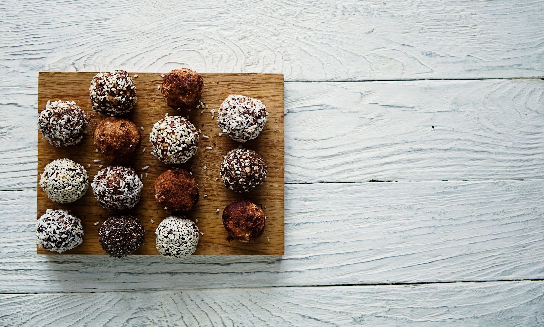Healthy raw energy balls on a white wooden background